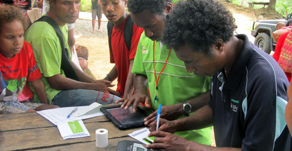 Farmer George Waire of Magautou village signs his new BSP card at Magaut. Credit: BSP
