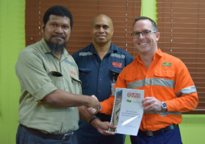 OTML HR Manager Harold Duigu (left) handing over the MOU to JKTech GM of Technology & Knowledge Transfer, Brett Cunningham (right), as OTML COO Musje Werror looks on. Credit: Ok Tedi Mining. Credit: Ok Tedi Mining.