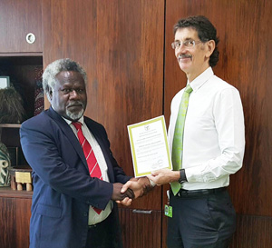 Reserve Bank of Vanuatu Governor Simeon Athy hands over the license for BSP Vanuatu Ltd to BSP Group CEO Robin Fleming. Credit: BSP